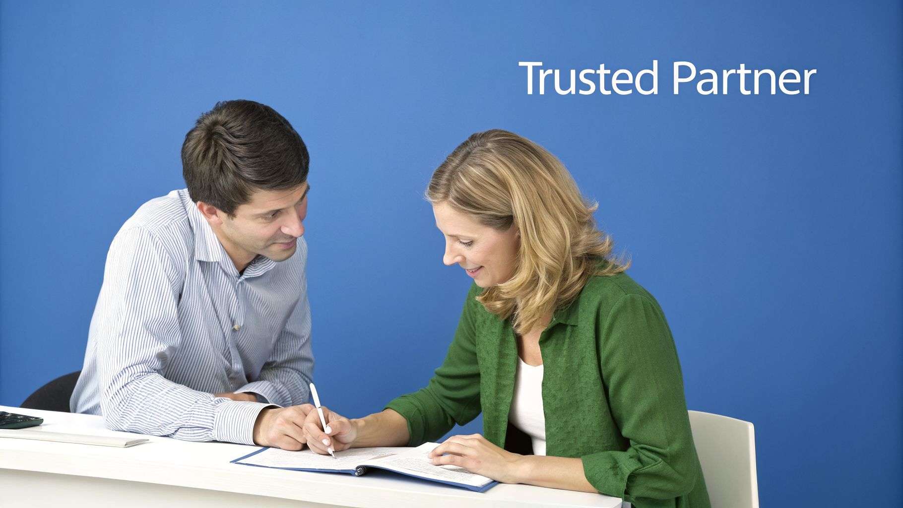 A man and a woman in a business meeting, signing documents at a white table. Text: Trusted Partner.