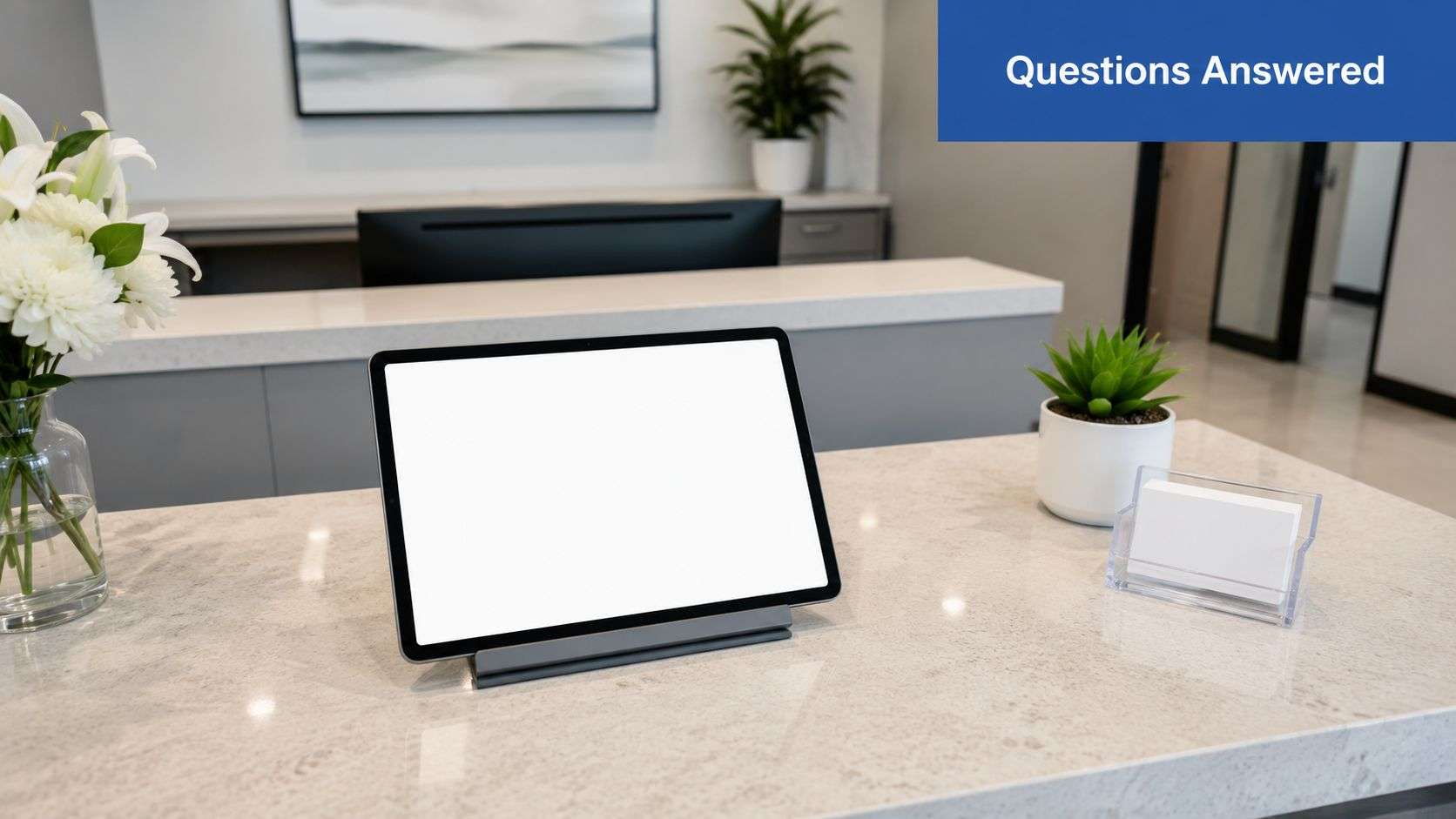 A modern medical office front desk featuring a tablet, flower arrangement, and professional reception counter.