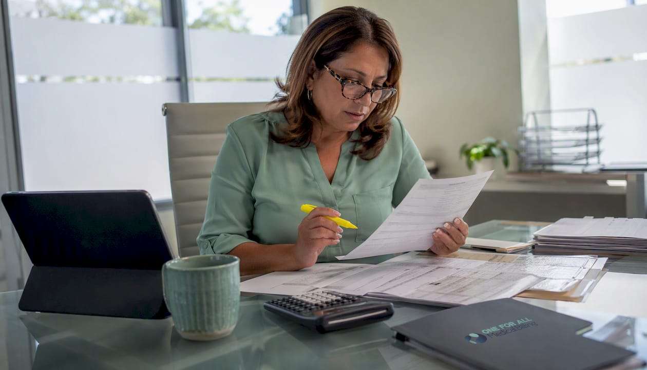 1785590137112_Billing-specialist-reviewing-ASC-CMS-documents - One For All Medical Billing Billing specialist reviewing ASC CMS documents
